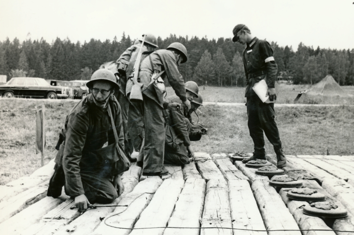 Rikshemvärnstävlingen 1967, sid 13

Min- och sprängtjänst.

Bild 1 och 2. Gruppen förbereder sprängning av en träbro med stridsvagnsminor. Minorna tänds med Sprängdeg och Pentylstubin.