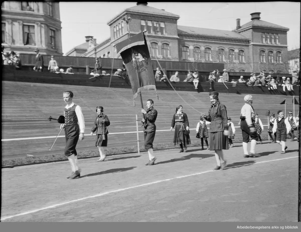 Barnelag fra Oslo, 1. Mai 1932 på Dælenenga idrettsplass. Grünerløkka skole i bakgrunnen. Arne Linderud med fiolin