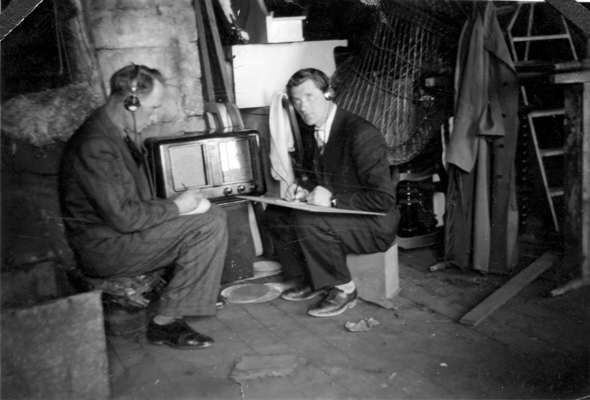Olaf Angell og Kåre Andreassen tar notater mens de hører på radio.