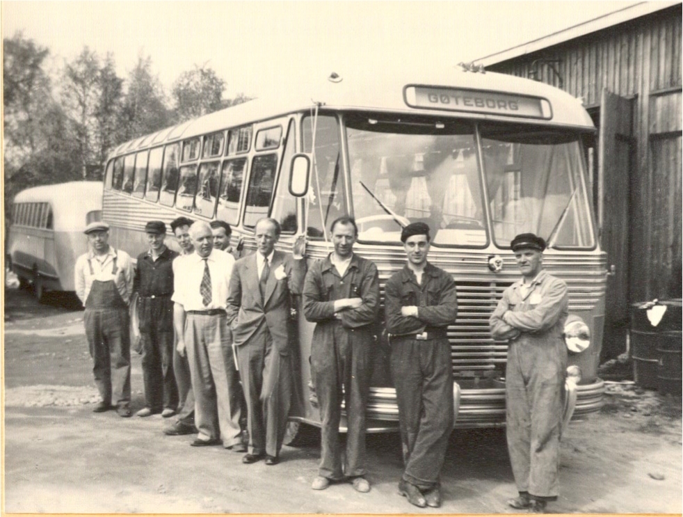 Personale ved NSB Hølandsrutene foran turistbuss utenfor verkstedet på Bjørkelangen
