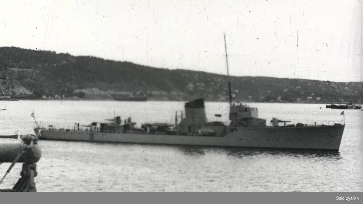 Kommandørkaptein Elias Corneliussen går om bord i lettbåt ved Rådhusbrygga. Bilder av eskadren, som ligger utenfor Pipervika i september 1937.