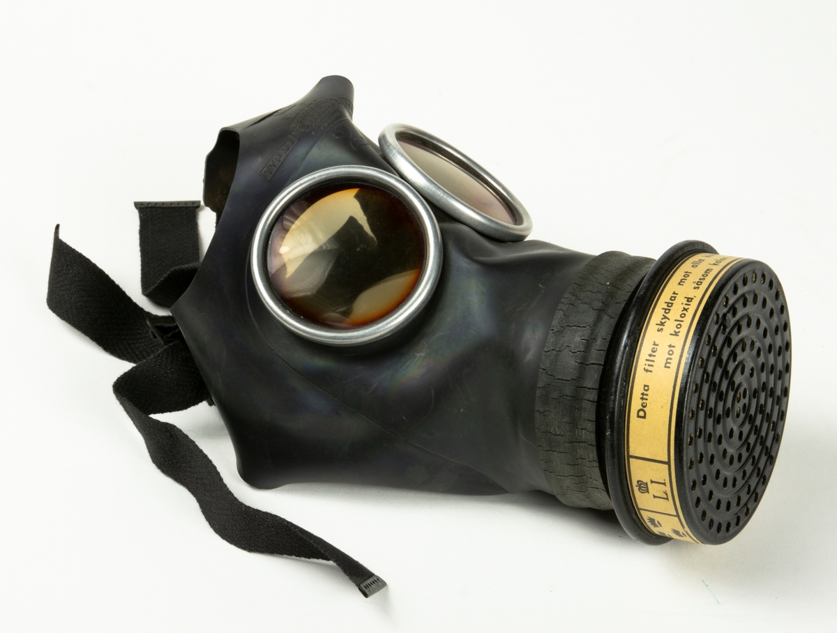 1. Gasmask med tygväska. Innehåller även instruktionsbok..
2. Gasmask av gummi med filter Typ 21.
3. Filter till gasmask, koloxidfilter M2311-721.