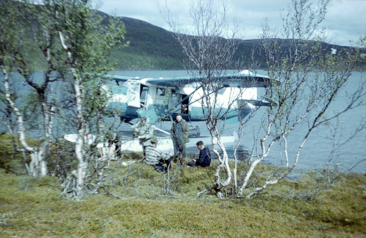 Norseman fra Nor-Wing fortøyd ved bredden av et vann. Taxiflyging med fisketurister, antagelig i Troms eller Finnmark.