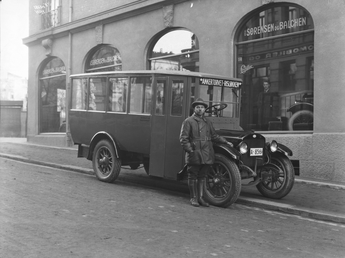 Rutebil, "Ankertorget - Risløkken", bussjåfør står foran bussen, Sørensen & Balchen A/S. Fotografert 1924.
NB: Bildet er tatt i Cort Adelers gate utenfor firmaets salgs- og utstillingslokale i Drammensveien 20.