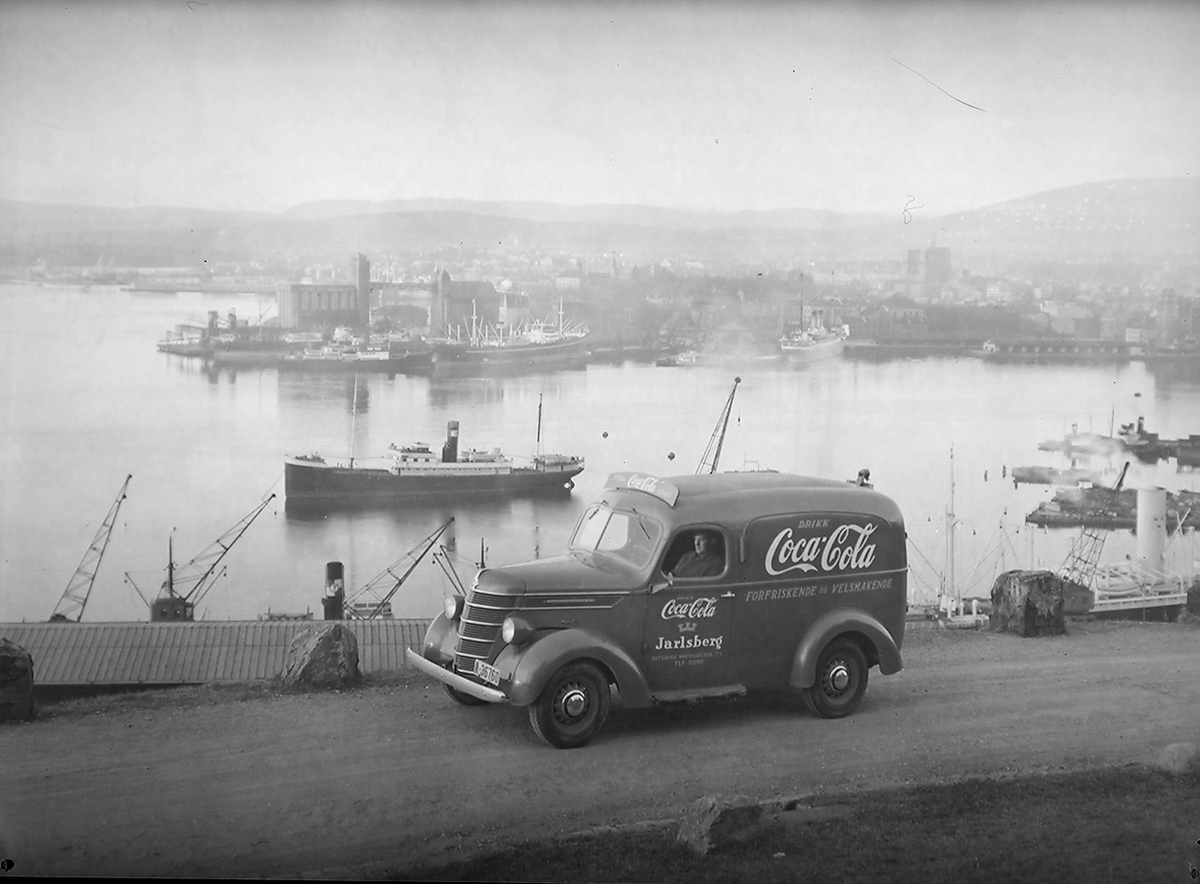 Coca-Cola- og Jarlsberg-bil A-36760. Havneområde båter og kornsilo på Vippetagen i bakgrunn. Fotografert 1939.