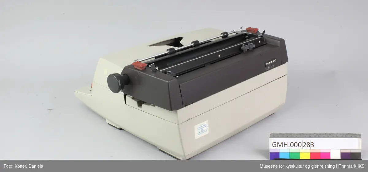 Denne elektriske skrivemaskinen laget av grå og brunt metall. Apparater mangler strømkabelen. 