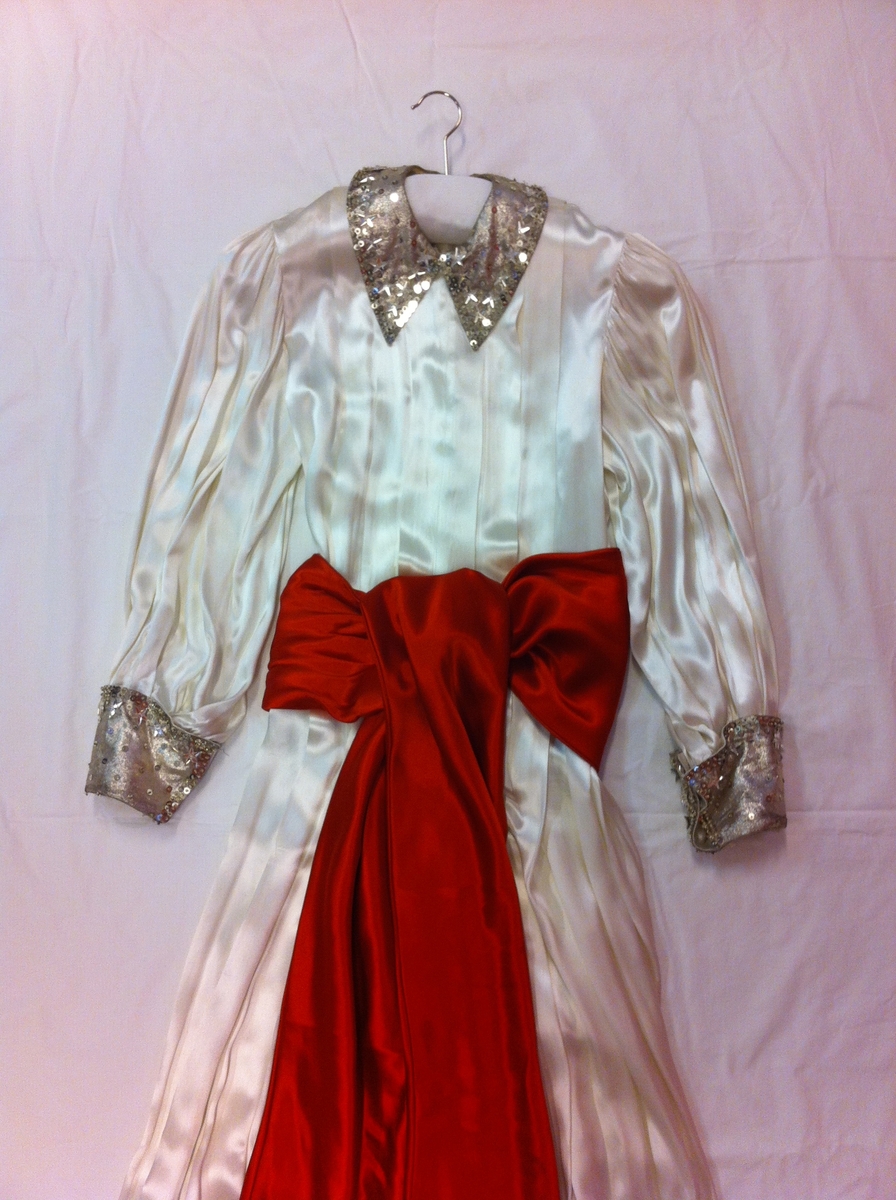 Luciaklänning med tillhörande rött skärp.
Stearin från ljuskronan har smutsat ner klänningen.