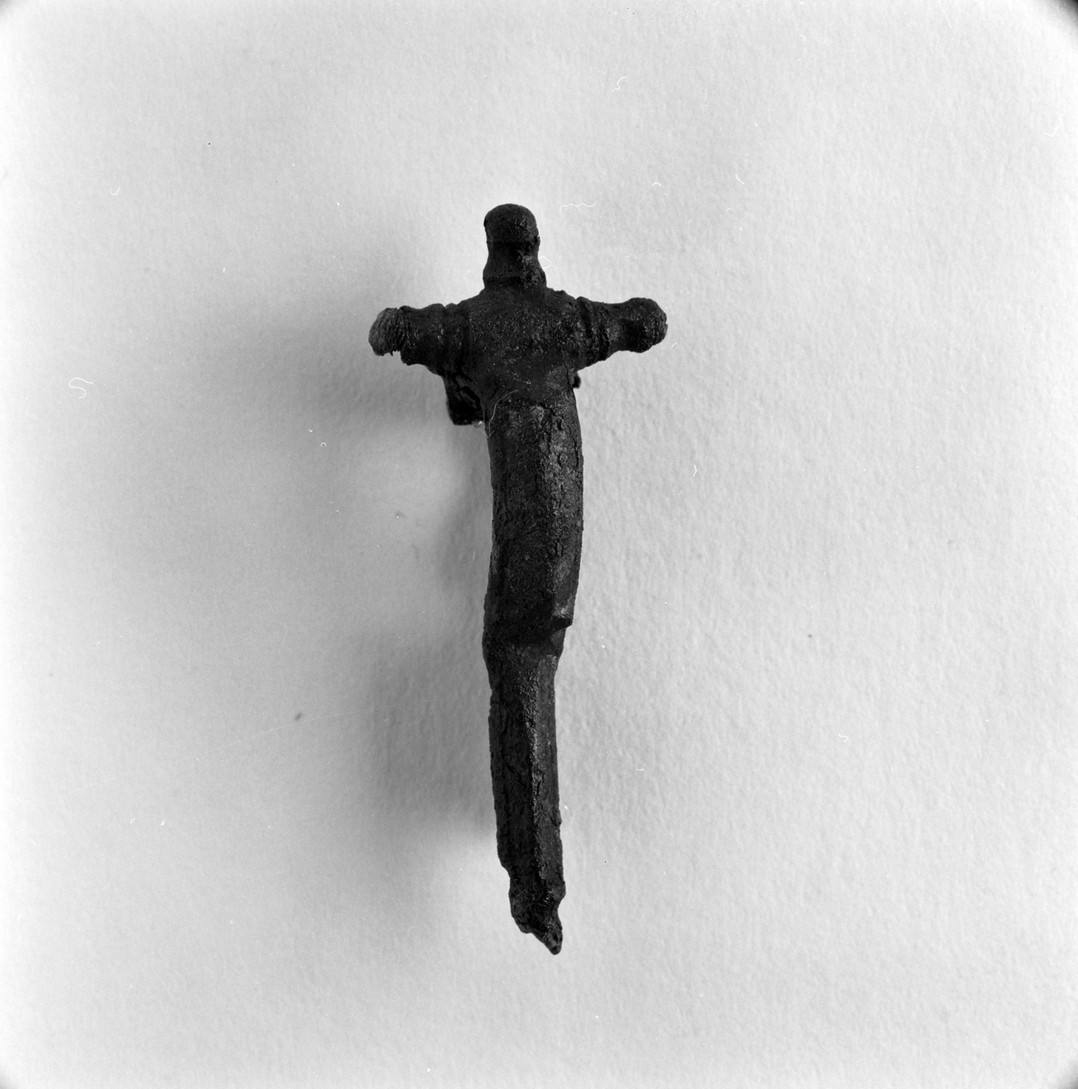 Ett dräktspänne, så kallad fibula som hittades vid en arkeologisk undersökning av ett gravfält i Byarum i Vaggeryds kommun. Fyndnummer JM.55938:96. Beskrivs som en korsformad bronsfibula med en nål av järn.