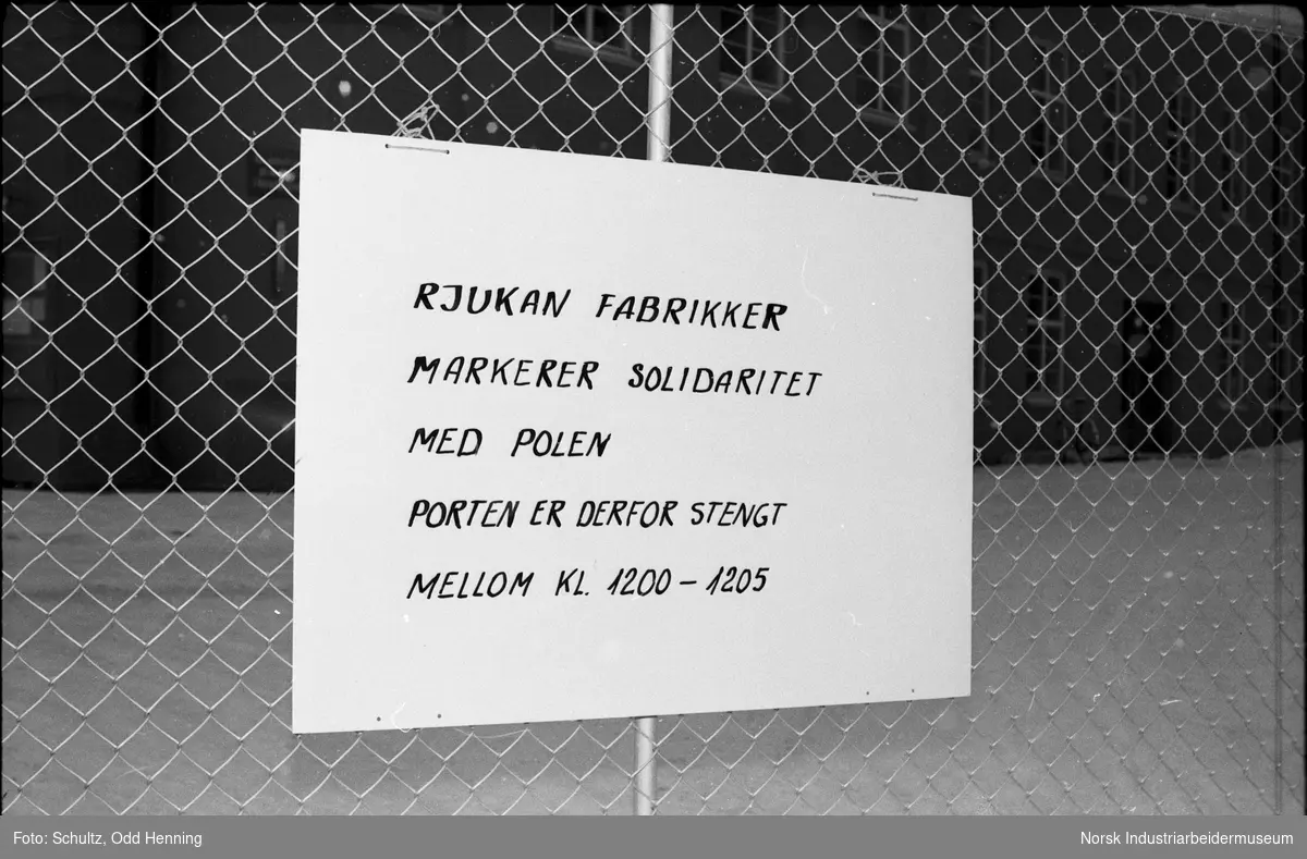Plakat på grinden ved Hovedporten hvor det står "Rjukan Fabrikker markerer solidaritet med Polen, porten er derfor stengt mellom 12:00 og 12:05".
