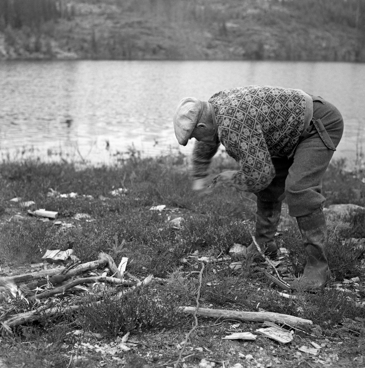Andreas Stenseth (1890-1972) fra Skogbygda i Løten, vrir viu til lenseknepper. Dette var bindsel av tre, som ble tredd gjennom hull ved endene av lensestokkene, som på denne måten ble lange, flytende stengsel. Stenseth tente seg et lite bål der «viuemnet» kunne «søyes» over varme for å bli smidig. Slike lenseknepper hadde Stenseth lært å lage ved Stendammen, som var inntaket til Stensåsrenna i Løten skogbygd.