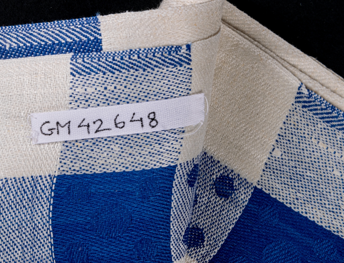 Oklippt, maskinvävd handduksväv av hellinne tillverkad vid Torsåkers linnefabriks aktiebolag. Vävd i tuskaft med naturfärgad botten med blåa effektränder.