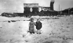 2 barn foran gruveanlegg.