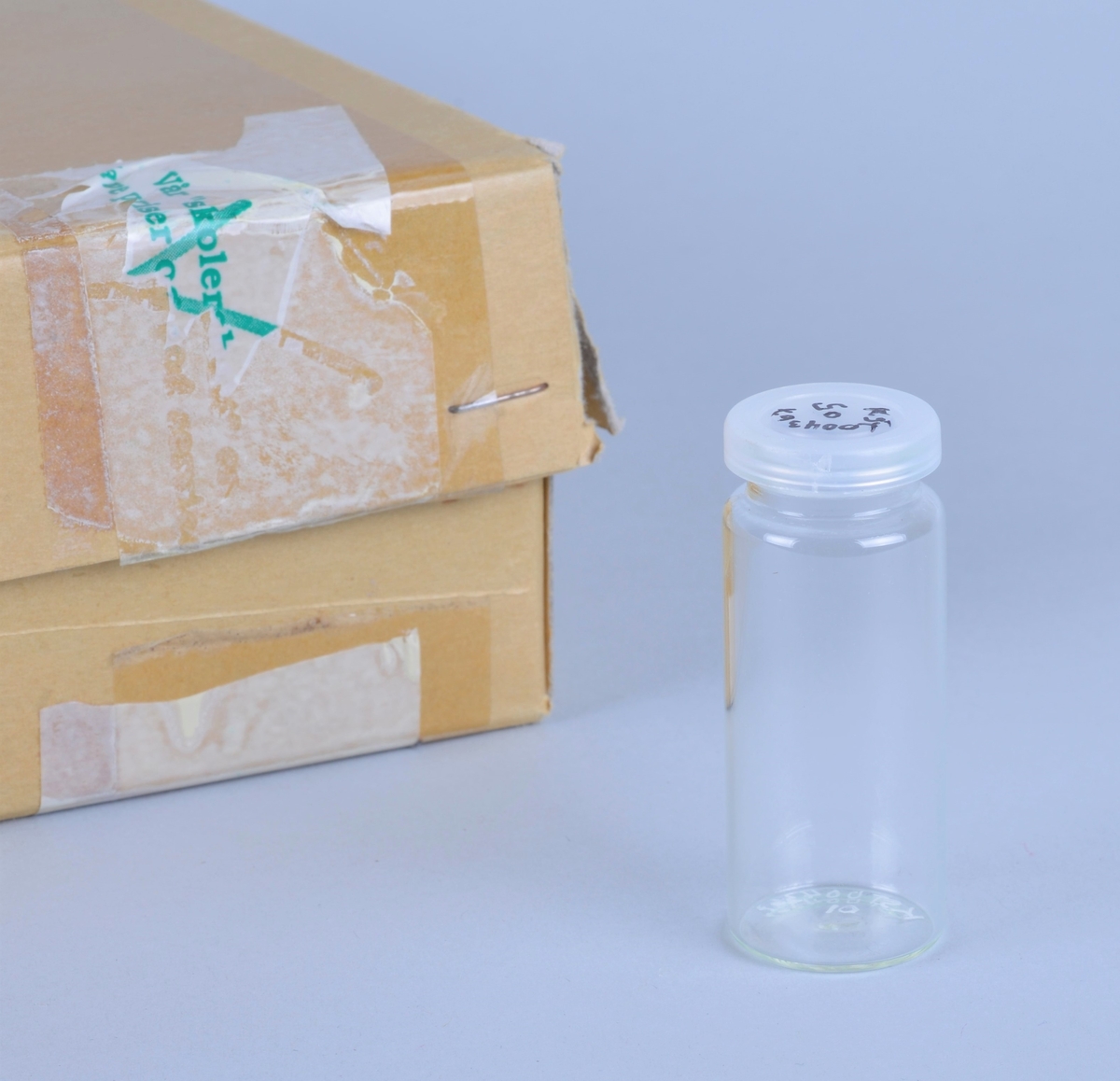 100 små, sylindriske glass med tilhørende plastlokk (130 stk).
Kanskje brukt ved prøvetaking eller oppbevaring av prøver.
Oppbevart i en pappeske