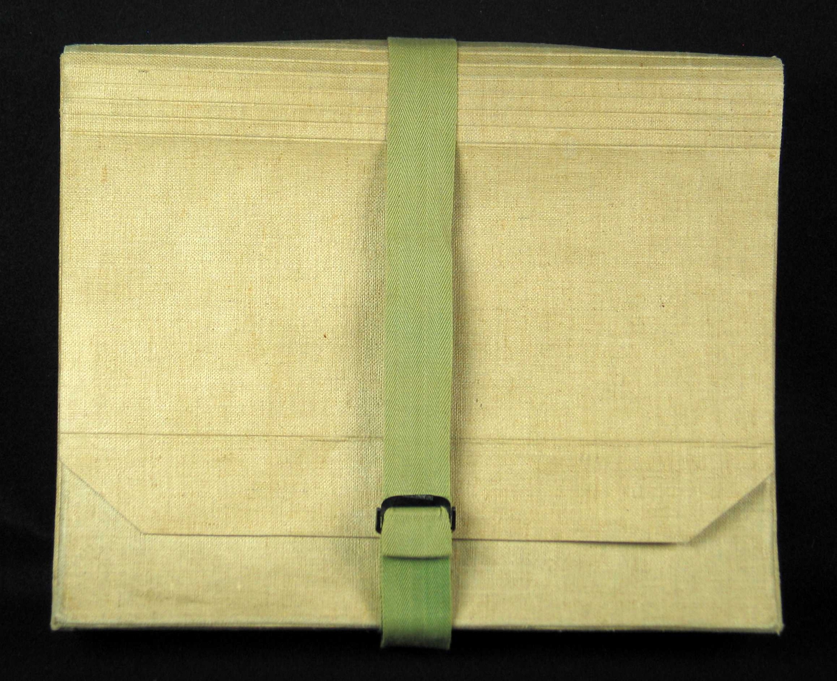 Grå arkivmappe i kartong trukket med kanvas. Grønt bånd med svart spenne.