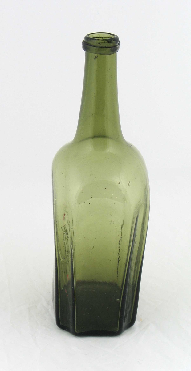 Grønn åttekantet flaske.