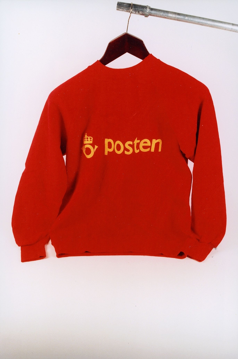 Rød genser med lang erm; Posten og postlogo er trykt foran, stor postlogo bak.
ex 1
Fotografi: PMF.9.0.02750, PMF.9.0.02751