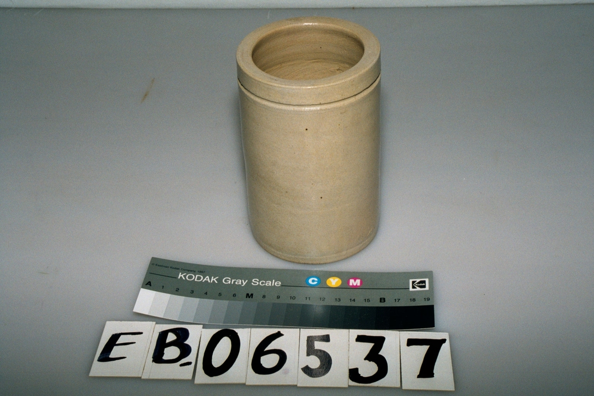 Form: sylinder, ca 1 cm nedenfor kanten er det et spor som lager et horisontalt bånd rundt krukka
