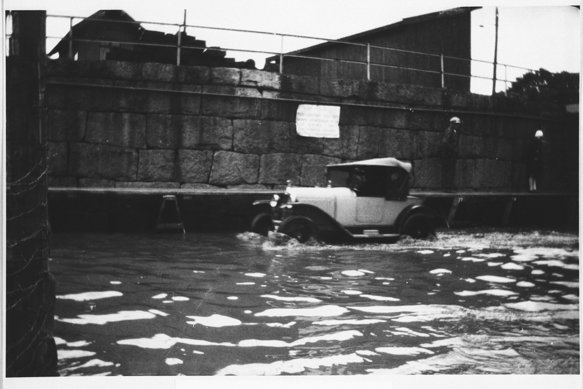 Bil på vei gjennom vannmassene under flommen i 1927.
