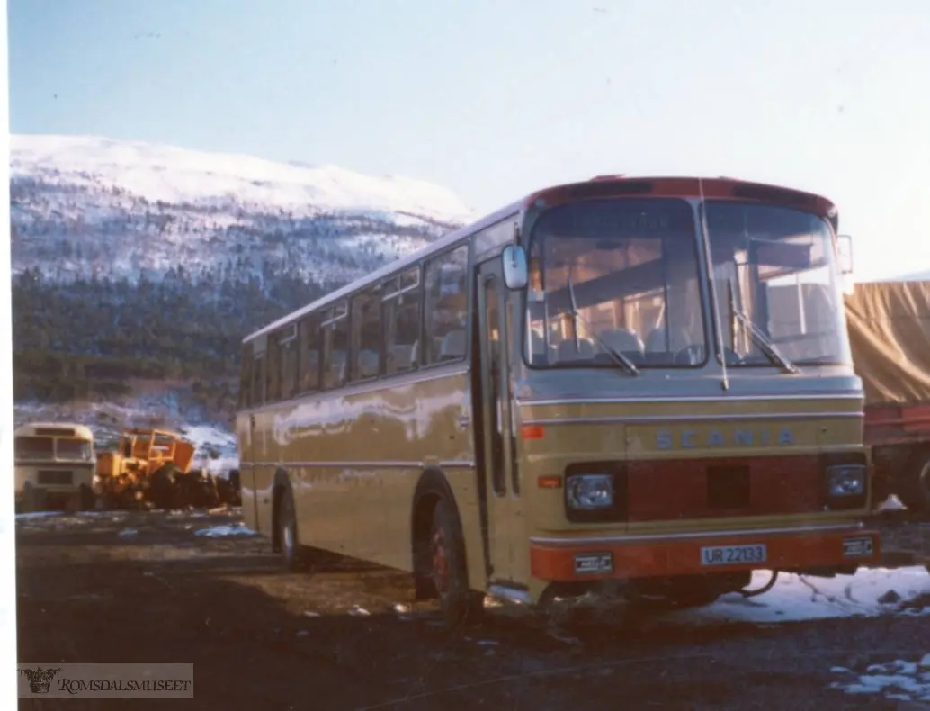 UR22133 var en Scania BR85 med karosseri fra Vest Karosseri. Bussen ble levert til Eira-Eidsvåg Billag (EEB) i mars 1975. Den hadde høy standard med 45 seter og fikk først i rute Molde-Sunndalsøra. I 1982 ble EEB slått sammen med Kristiansund-Oppdal Auto (KOA) og bussen ble lakkert i fargene til KOA, blå, brun og sølvfargede striper. Bussen var i bruk som rutebuss til 1993, de siste åra først og fremst i skoleruter i Nesset og Sunndal. Bildet er antakelig tatt i Eidsvågen mens bussen var ganske ny...(fra Oddbjørn Skjørsæter sine samlinger i Romsdalsarkivet)