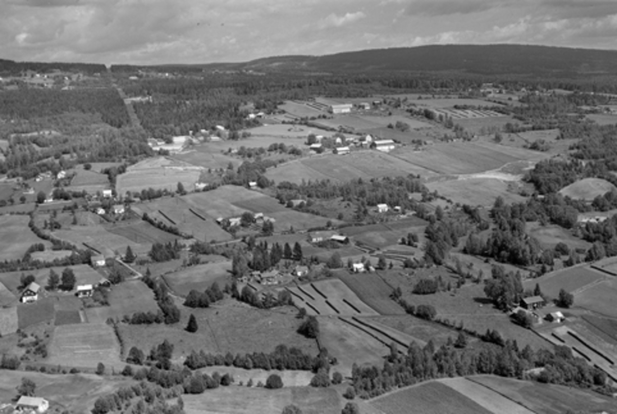 Flyfoto av Kylstad-gardene. Kirkeby øverst til høyre. Ellers Kylstadenga, Øvergård og Nergård, Sandli m fl. Furnesåsen, flyfoto, landskap.