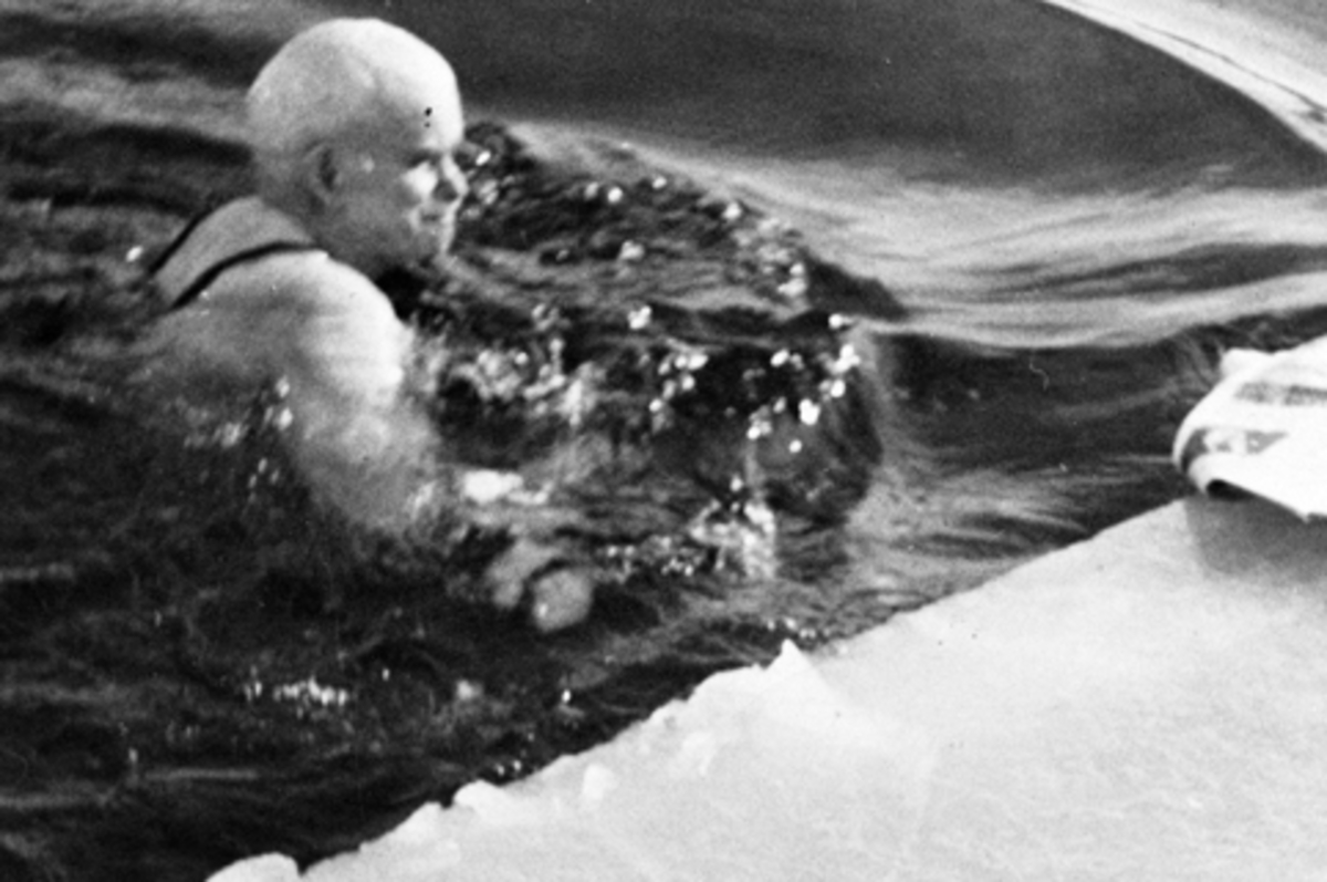 Isbading. Emil Husebye svømmer i råka ved Nerkvernbrygga, Brumunddal. 18 kuldegrader. Mjøsa er islagt.