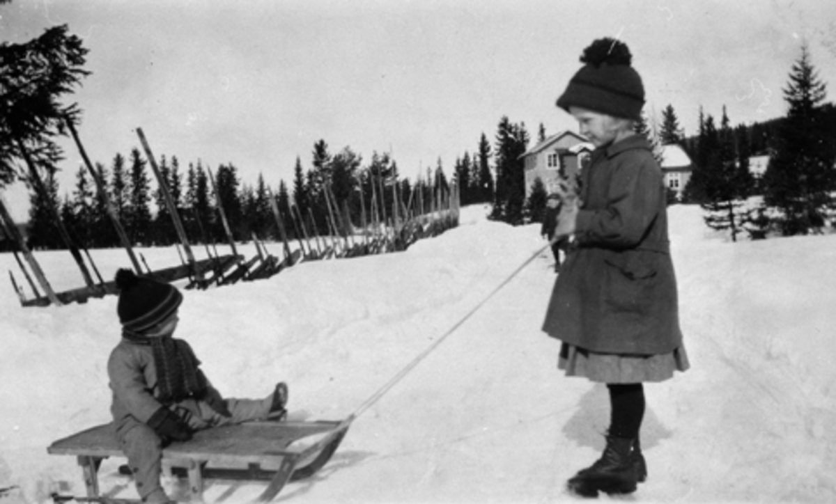 Sverre på kjelketur med storesøster, ca. 1925. Arnestad søndre, Mesnalia, Ringsaker.