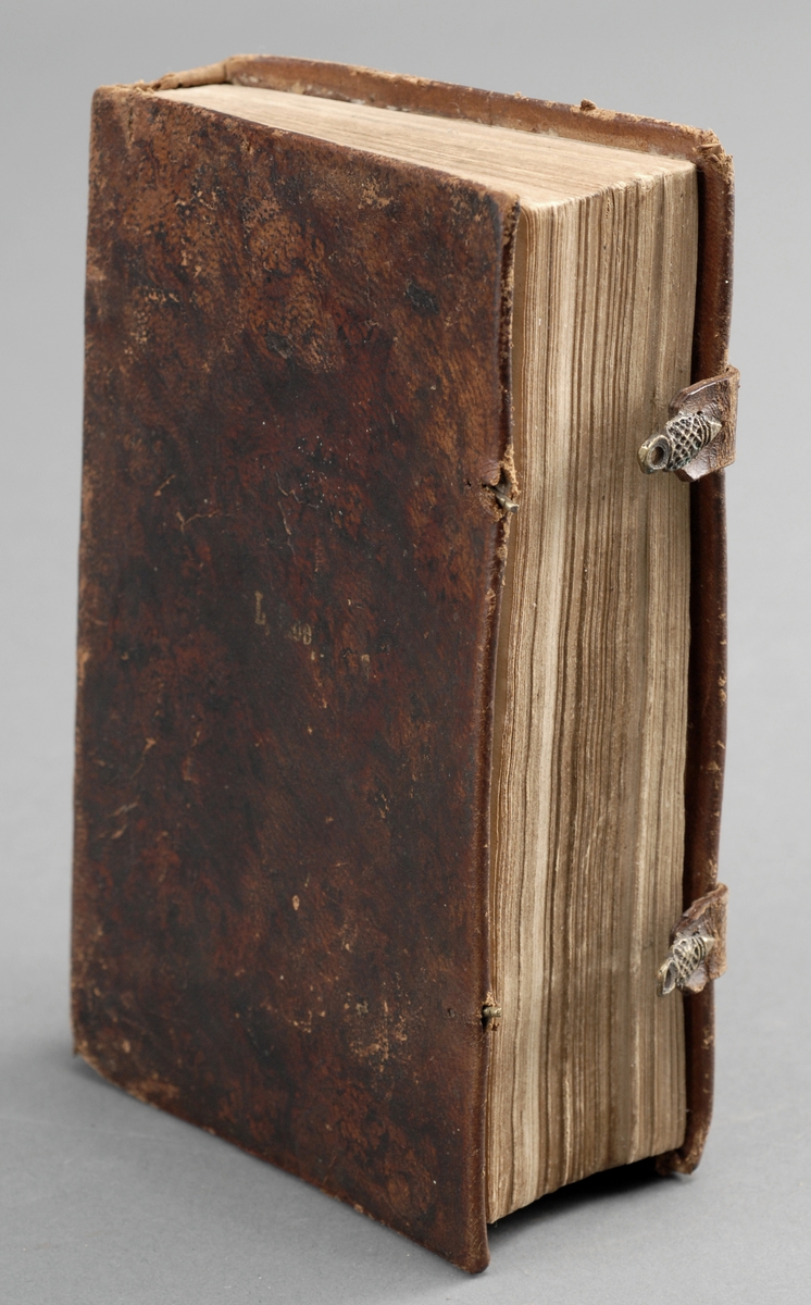Boken er  et helbind i marmorert skinn.
Rester av tekst på framsiden.
Låsemekanisme av skinnrem og metallhekte.
Boken har religiøst innehold.
Håndskrevet tekst inne i permen.
Teksten er i gotisk skrift.