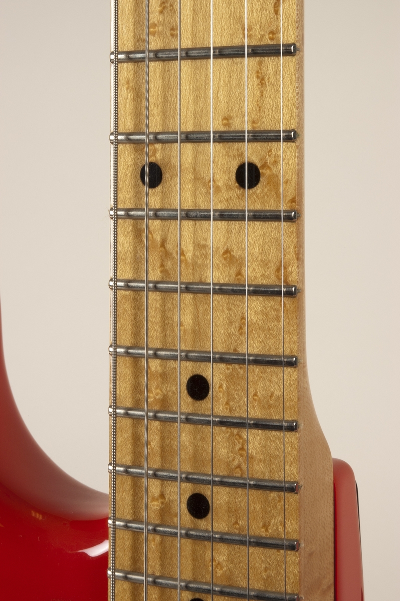 El-gitar med en finish i rød celluloselakk. Hals av fugleøyelønn. Pickuper av type Seymour Duncan Antiquity. Masterkontroll for volum og tone.