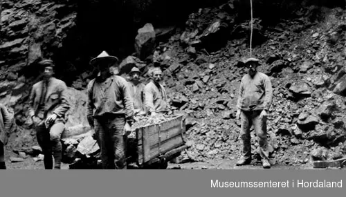 Arbeidarer/rallare/slusk ved ein tralle fylt med stein frå utgraving