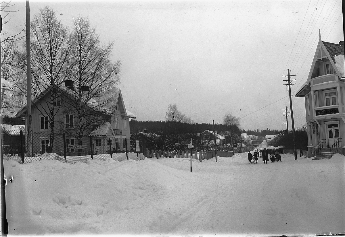 Ringsaker, Moelv sentrum, krysset Storgata-Åsmarkvegen, til venstre Ringsaker Privatbank opprettet i 1918 i gamle baker Ruuds gård fra 1894, Storgata 107, til høyre M. P. Doblougs gård, vinter på riksveg 50,