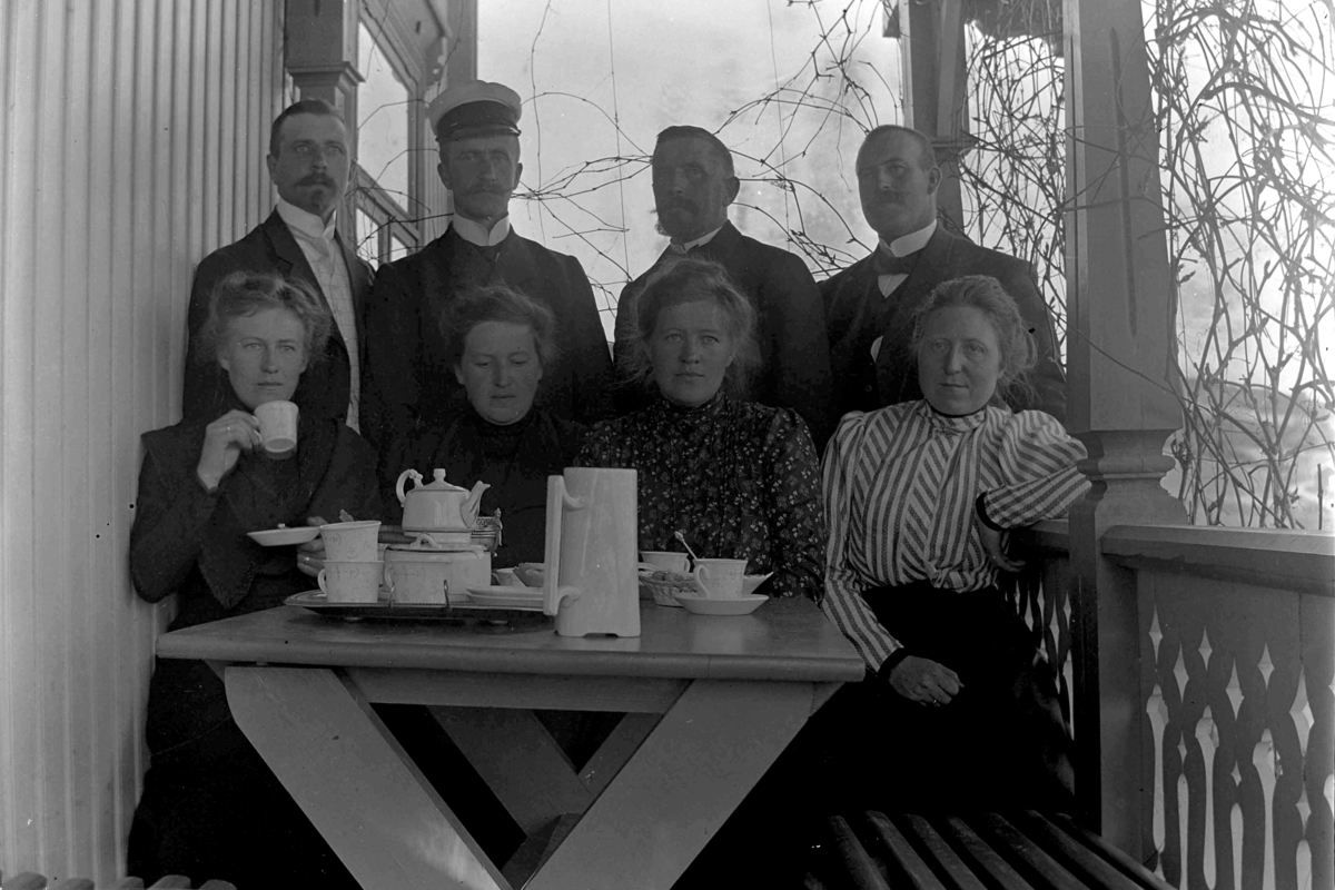 Ringsaker, Veldre, Haugen, gruppe 8, veranda, kaffe, kaffeselskap, kaffeservice. Bildet er fra verandaen på Haugen og viser fire søsken med respektive ektefeller. I bakre rekke, fra venstre: Halvor Skappel (1872-), Ole Hersoug (1880-), Ole Løken (1860-1924)(fotografen) og Barthold Ring (1881-1951). I fremste rekke: Antonette Lally Skappel (f. Ring) (1877-), Anonette Tulla Hersoug (f. Ring) (1883-), Wilhelmine Mimi Løken (f. Ring) (1876-1953) og Agnethe Ring (f. Jahren).