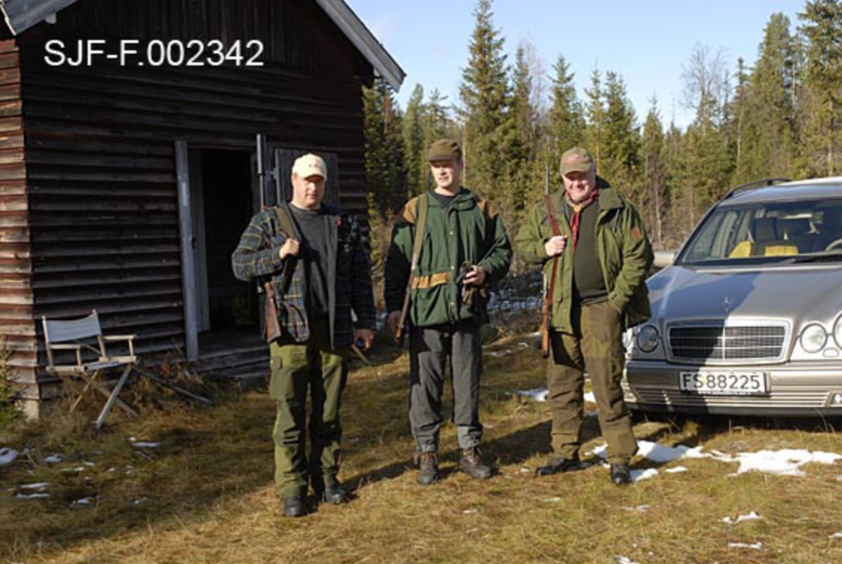 Elgjegerne Kjell Olav Nordbekk, John Svendsberget og Arnt Svendsberget foran Firerkoia på Jernskallen i Åmot. 