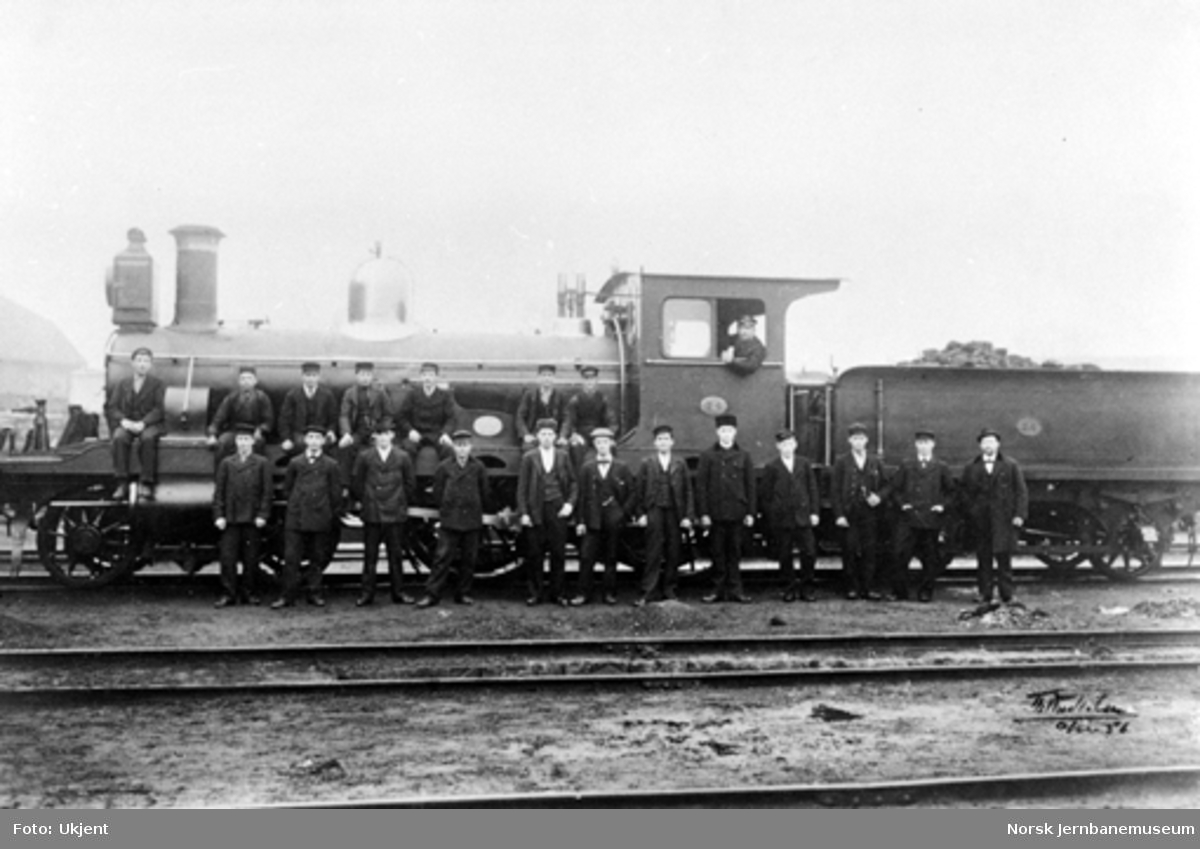 Jernbanefolk oppstilt for fotografering foran damplokomotiv type 13a nr. 74