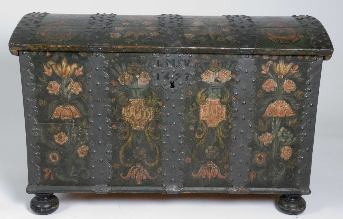 Kiste med buet lokk og heldekkende rosemaling, hvorav mye er senere tilføyelser eller restaureringer. Kulebena er også sekundære.