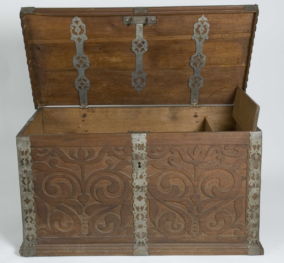 Kiste med flatt lokk, skåret dekor i flatt relieff. Gjennombrudte fortinnede jernbeslag.
