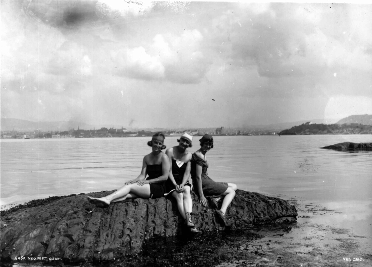 Oslo. Tre kvinner i badedrakt på et svaberg i Oslofjorden. 1927. Øyene og byen i bakgrunnen.