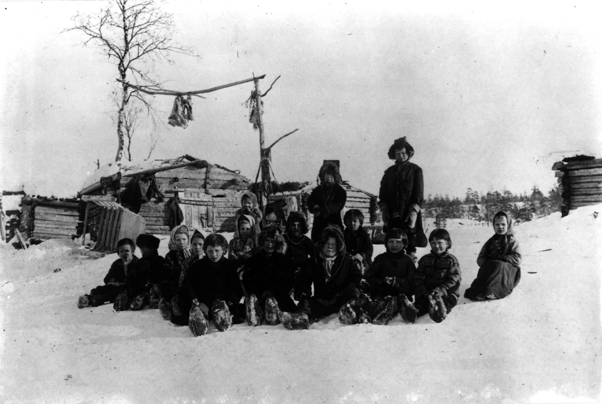 Elever og lærerinne utenfor skolehuset i Sandnes eller ved vinterboplass i Øvre Skolteby, Pasvik, Sør-Varanger, Finnmark, før 1897.
