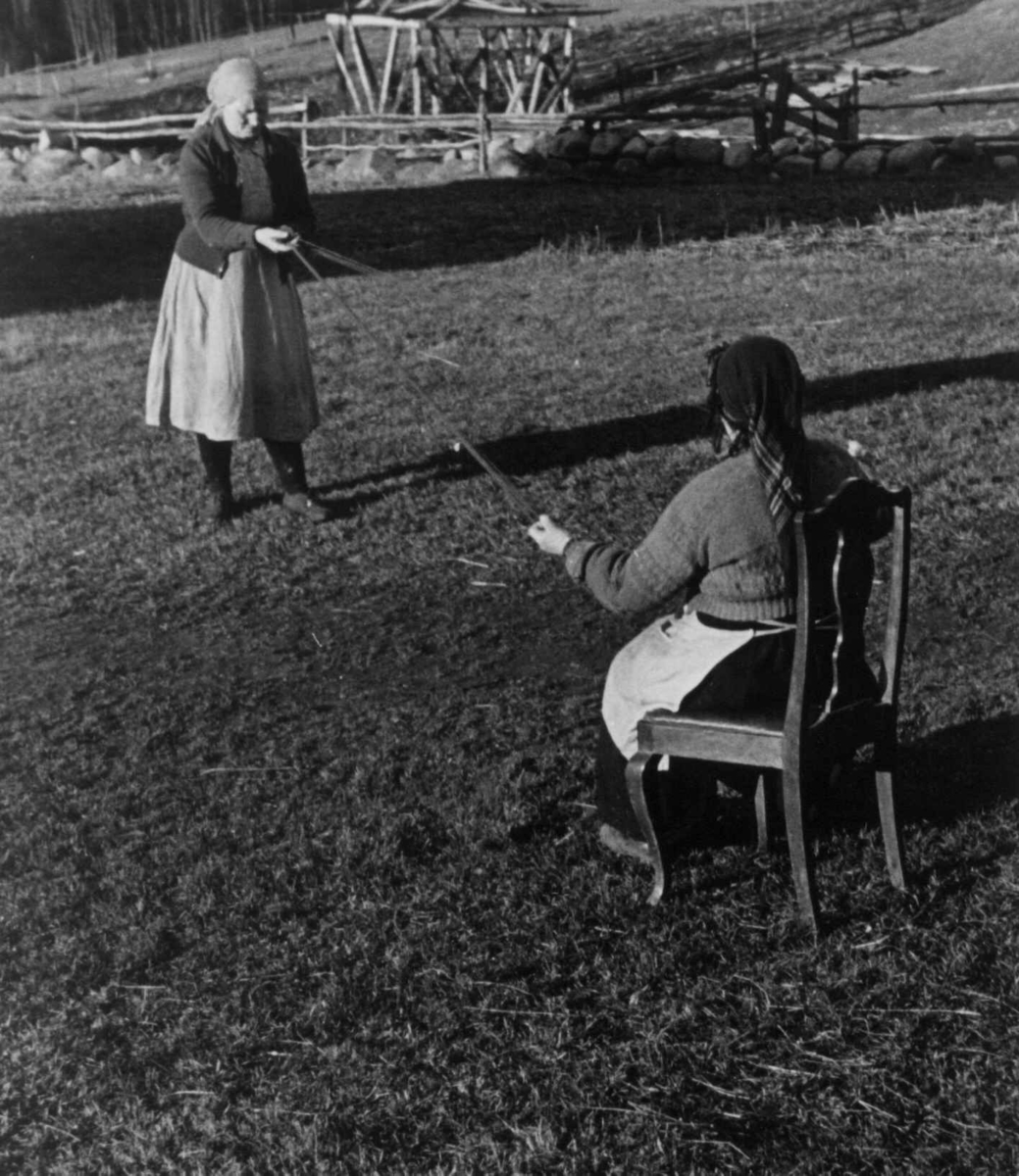 Bondekone Kristi Espeli og datteren lager snor til å ha nederst på stakk og kjoler. Åseral, Vest-Agder 1943.