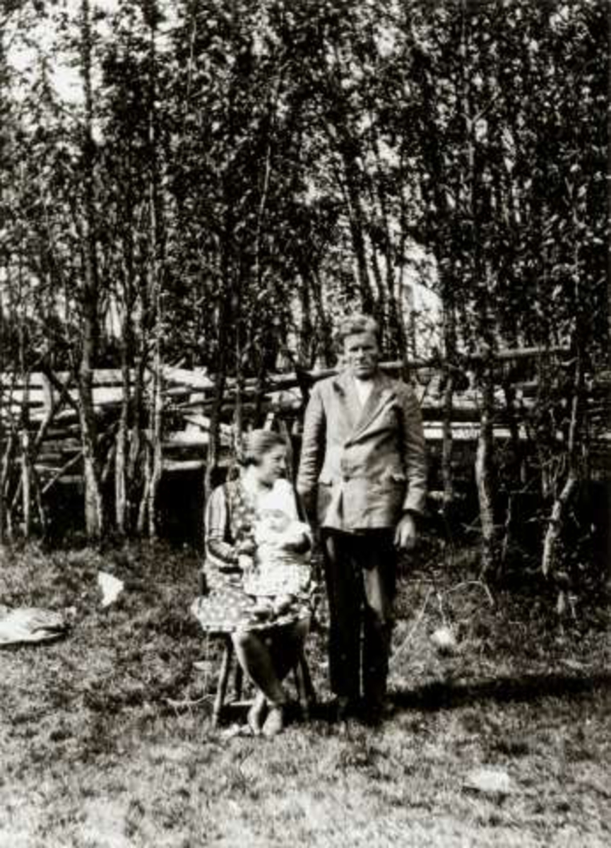 Barne- og voksendrakt, Budalen 1932. Alma og Ole Presthus med sønnen Edvin fotografert på Bjerkenås i skogholt.