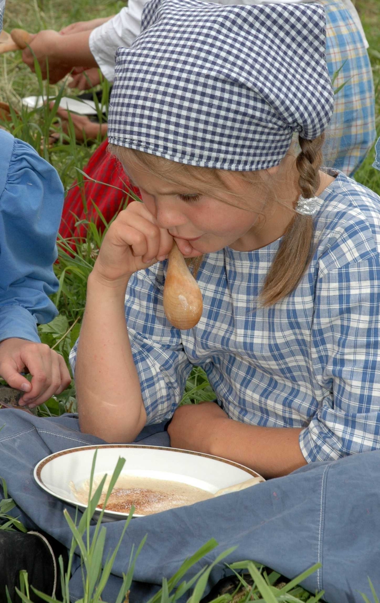 Levendegjøring på museum.
Ferieskolen uke 30 i 2005.Det tas pause i høyinga. Alle slapper av og spiser slåttegrøt.
Norsk Folkemuseum, Bygdøy.