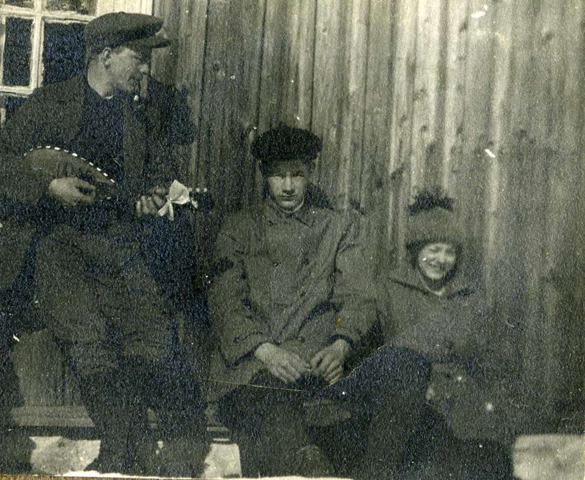 To menn og en kvinne, en av mennene spiller mandolin. Ca. 1920