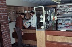 To menn ser i en perm ved skranken på Hemne apotek i Kyrksæt