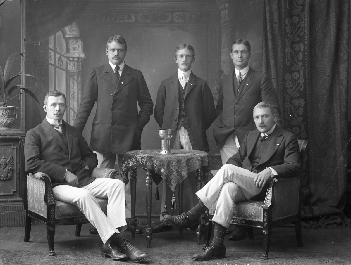 Gruppeportrett, fem herrer i dress med pokal.
Kristiania roklub  01.09.1910