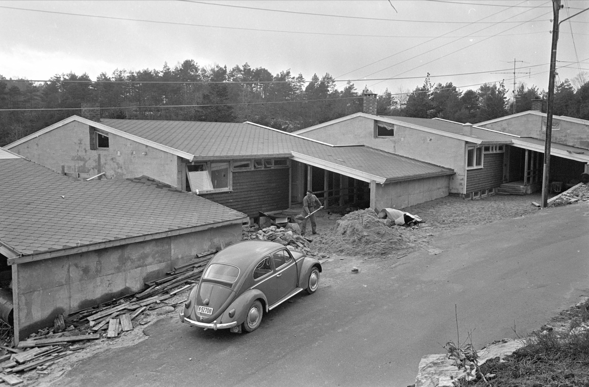 Antakelig fra Einerstien i Voiebyen i Kristiansand i 1967. Bil av typen Volkswagen Boble foran hus som er under bygging.