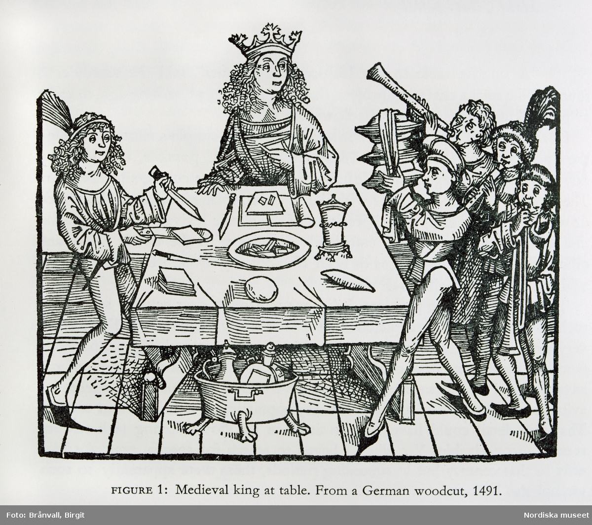 Träsnitt. Måltidsscen från 1500-talet. "Serveringskärlen kunde bäras in staplade på varandra. Här är försnidaren i full aktion och musikanterna gör sitt för att höja stämningen. En fyrkantig träskiva att äta på kallades qvadra"