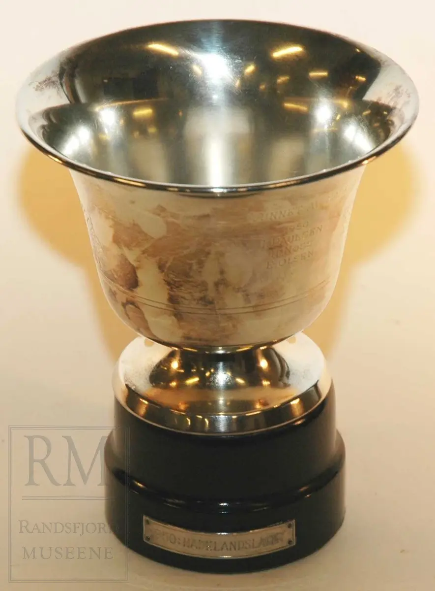 Form: Pokal i sølv, fot i tre, filt under foten
