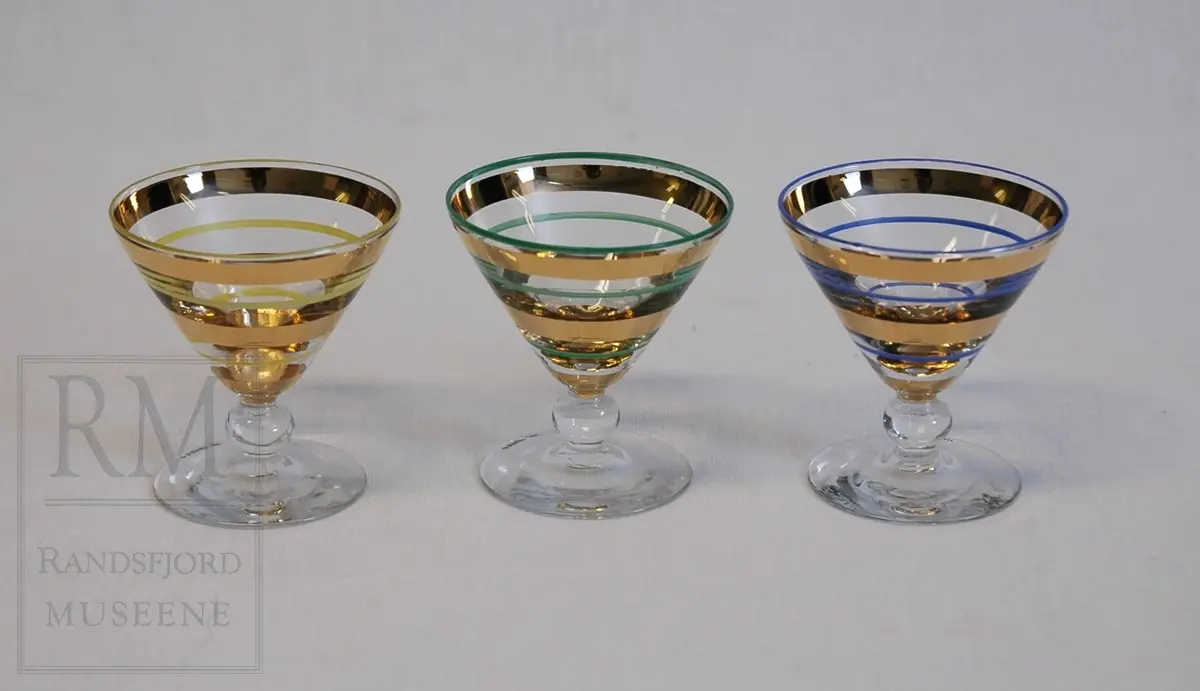Flat fot. Kort stett med kule på midten. Traktformet cupe. Horisontale striper på cupen. Annenhver gull og henholdsvis blå, gul, grønn (a, b-c, d-g).
