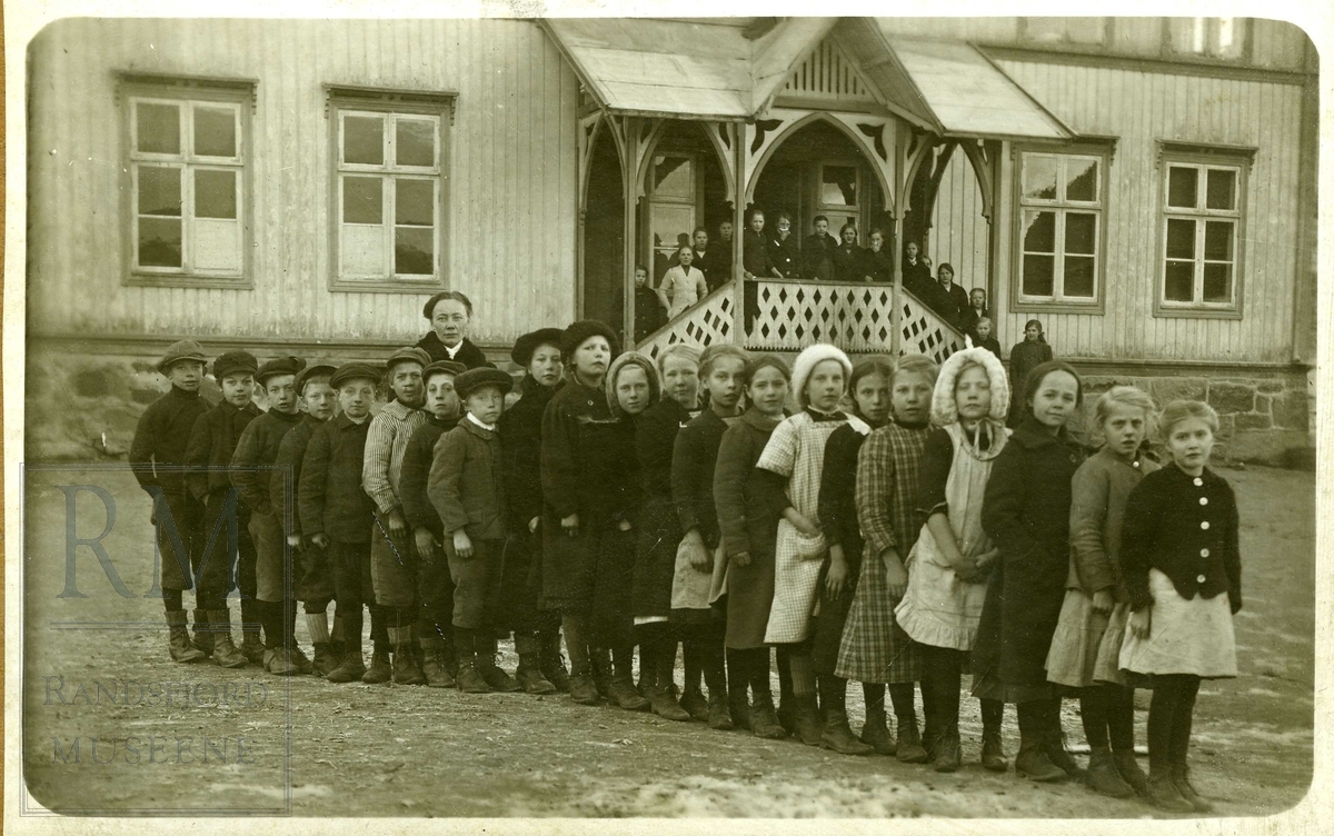 Skoleelever i 3. klasse oppstilt på rekke foran Lundby skole med lærer Martha Ruden. 