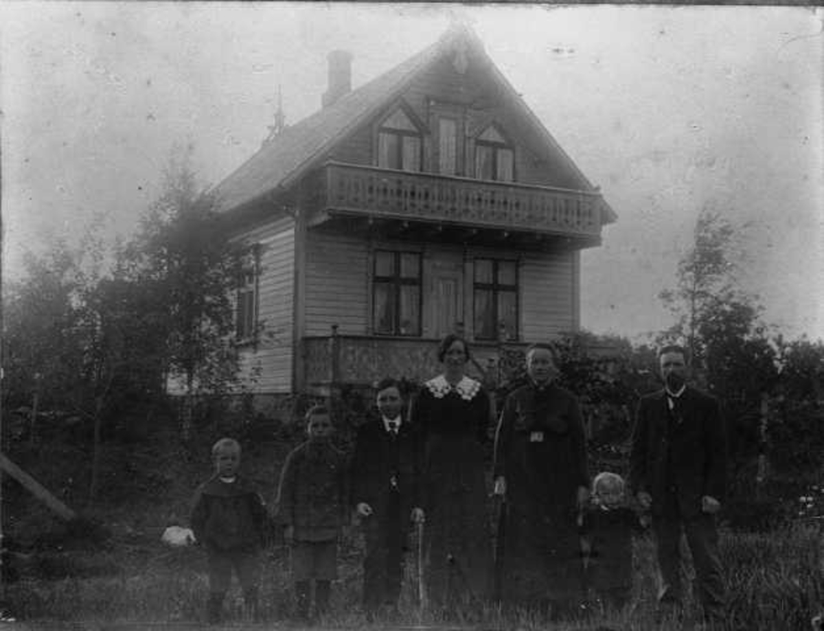 Familie foran bolighus