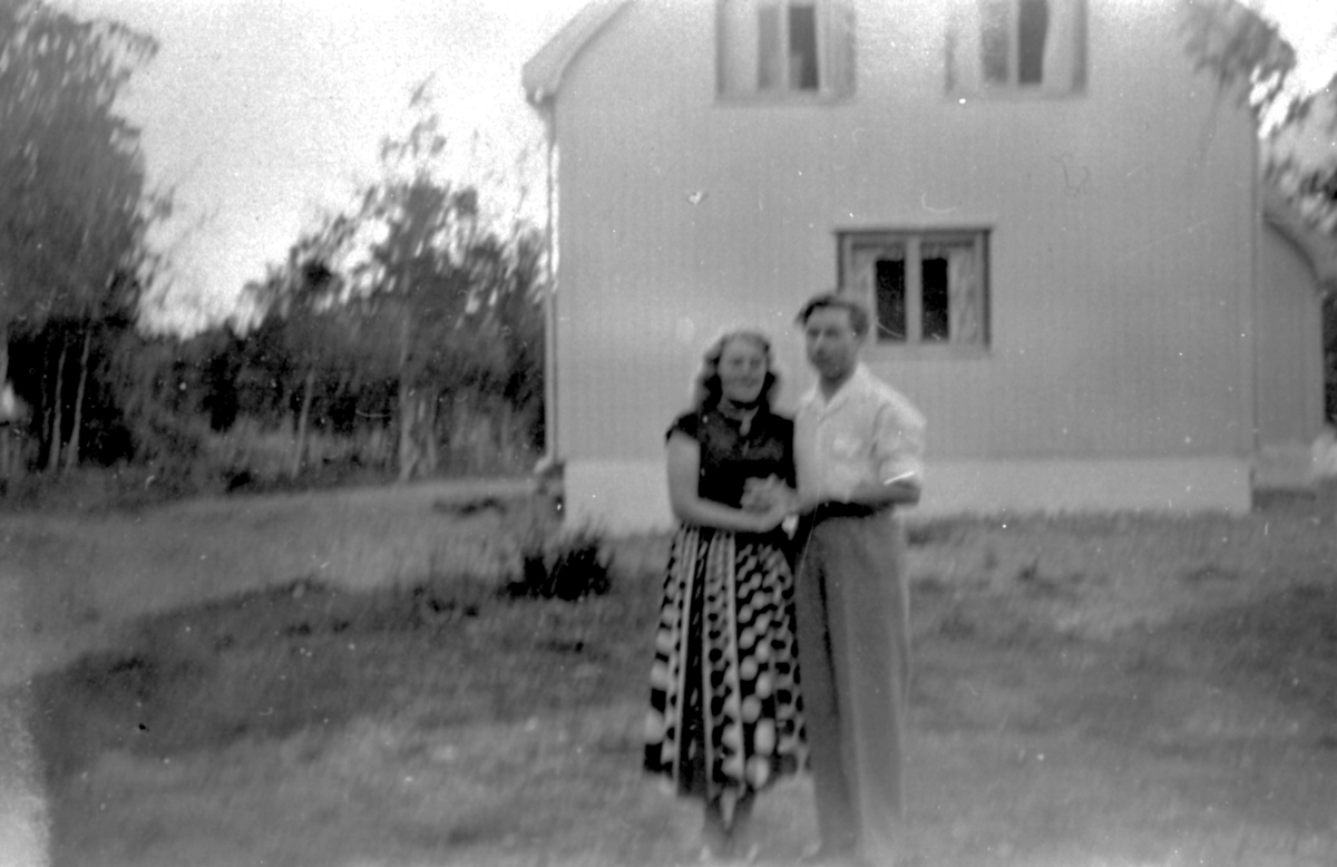 Portrett av kvinne og mann utenfor et hus. Gulborg Severinsen og Håkon Severinsen, Sønnli ca. 1955.